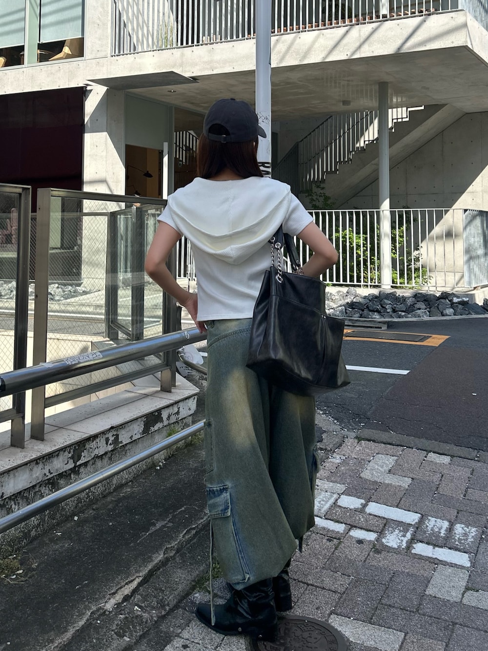 ホワイト系のTシャツ/カットソー、ブルー系のデニムパンツ、グレー系のキャップを着用したレディースの春コーディネートの3枚目の写真