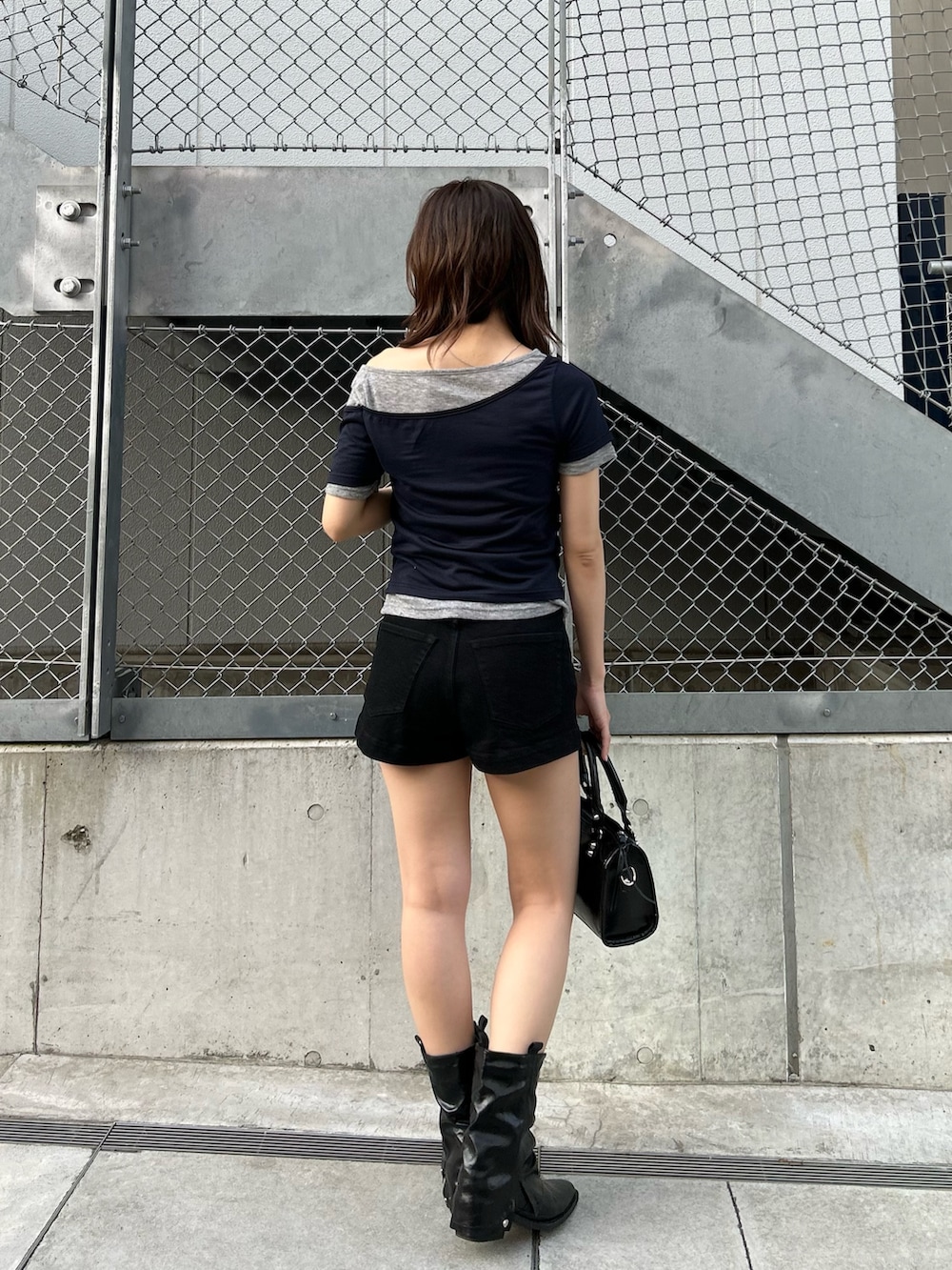 ブラック系のその他パンツ、ブラック系のショルダーバッグ、ブルー系のTシャツ/カットソーを着用したレディースの春コーディネートの4枚目の写真