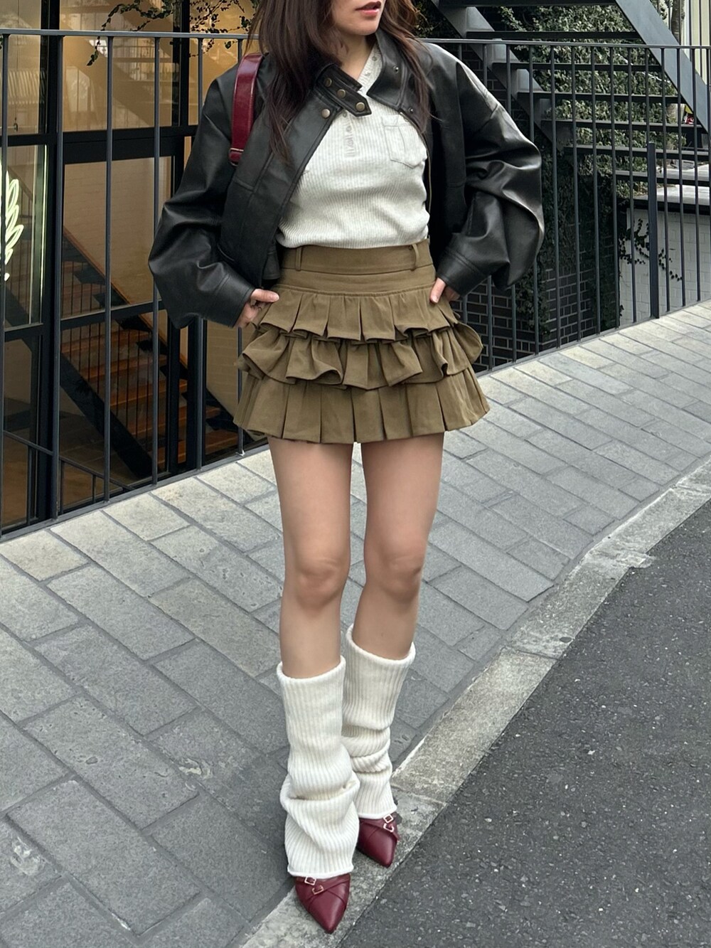 ブラウン系のその他アウター、グリーン系のスカート、ホワイト系のレッグウォーマーを着用したレディースの冬コーディネートの5枚目の写真
