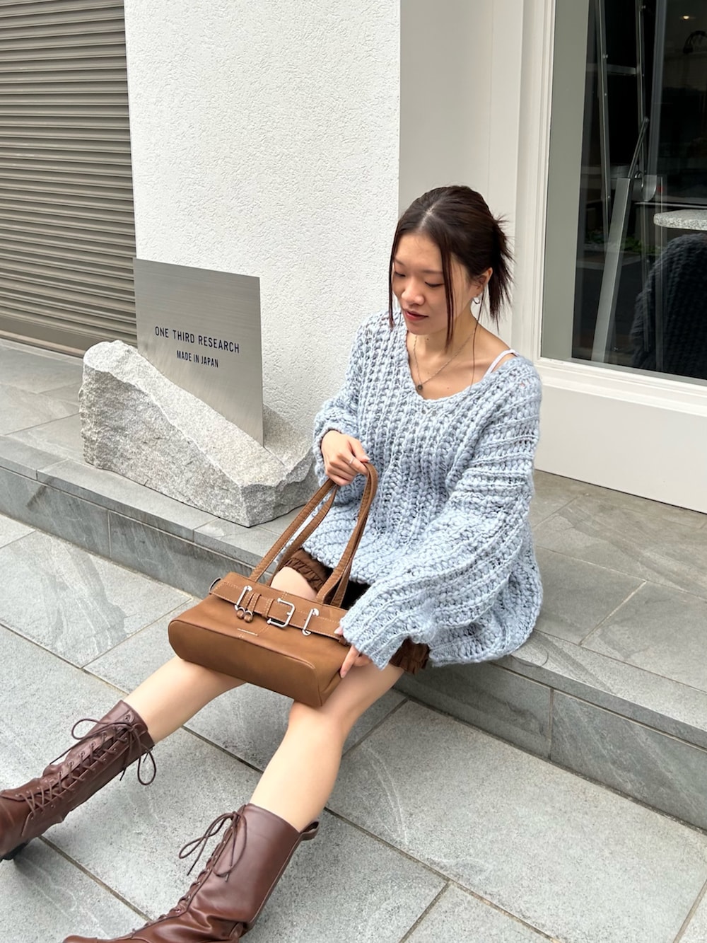 ブルー系のニット/セーター、ブラウン系のスカートを着用したレディースの秋コーディネートの5枚目の写真