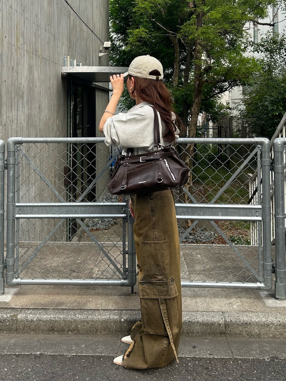 ホワイト系のカーディガン/ボレロ、ベージュ系のデニムパンツ、ホワイト系のキャップを着用したレディースの春コーディネートの2枚目の写真