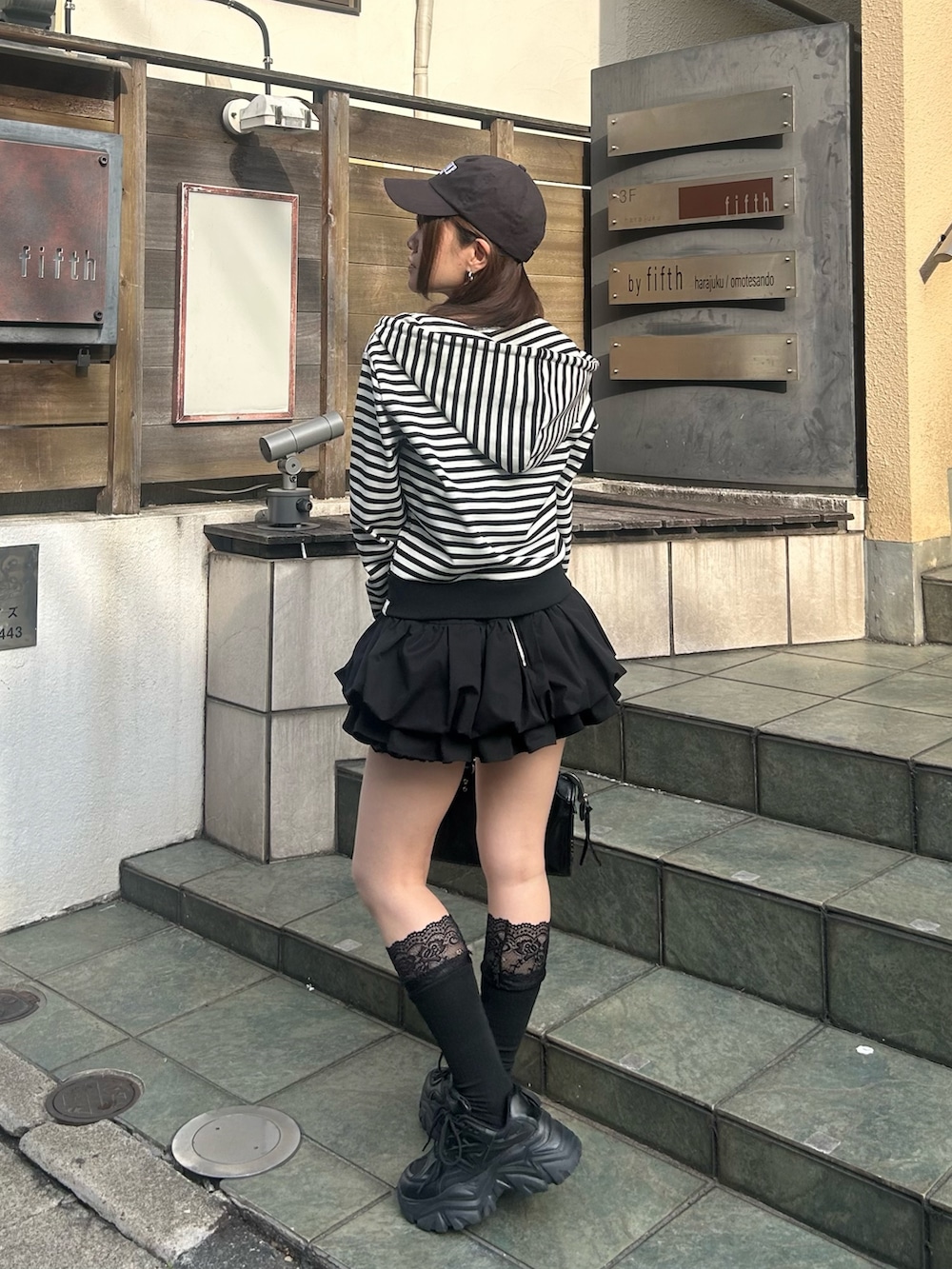 ブラック系のスカート、ブラック系のショルダーバッグ、ブラック系のソックス/靴下を着用したレディースの春コーディネートの2枚目の写真