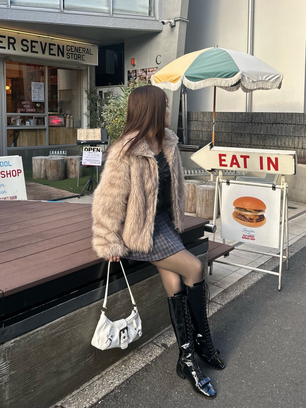 グレー系のTシャツ/カットソー、ブルー系のスカート、ホワイト系のショルダーバッグを着用したレディースの冬コーディネートの5枚目の写真