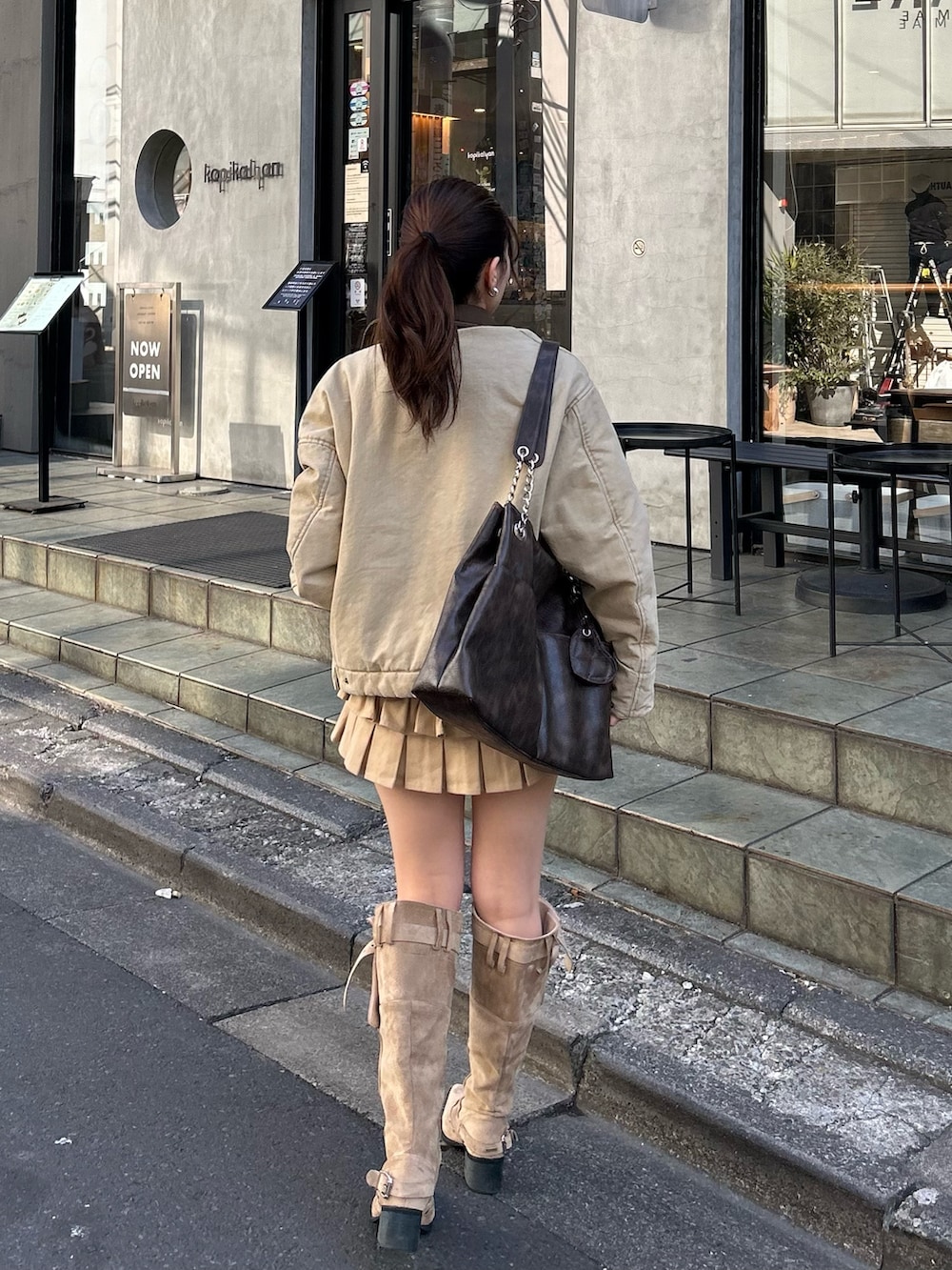 ベージュ系のブルゾン、ブルー系のTシャツ/カットソー、ベージュ系のスカートを着用したレディースの冬コーディネートの3枚目の写真