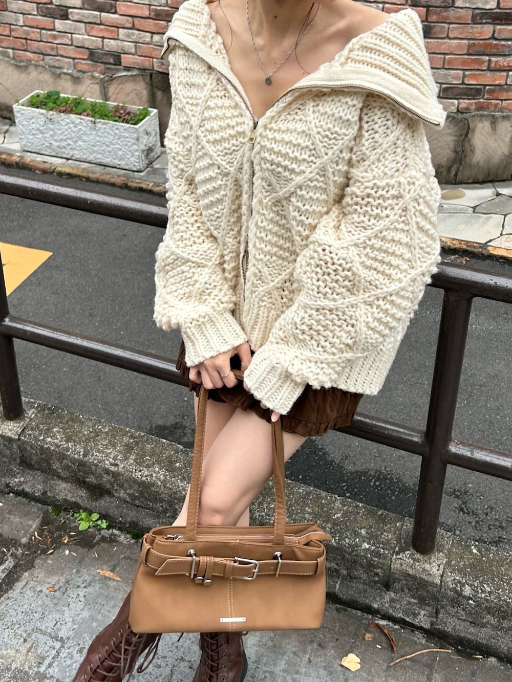 ホワイト系のニット/セーター、イエロー系のショルダーバッグ、ブラウン系のスカートを着用したレディースの秋コーディネートの4枚目の写真