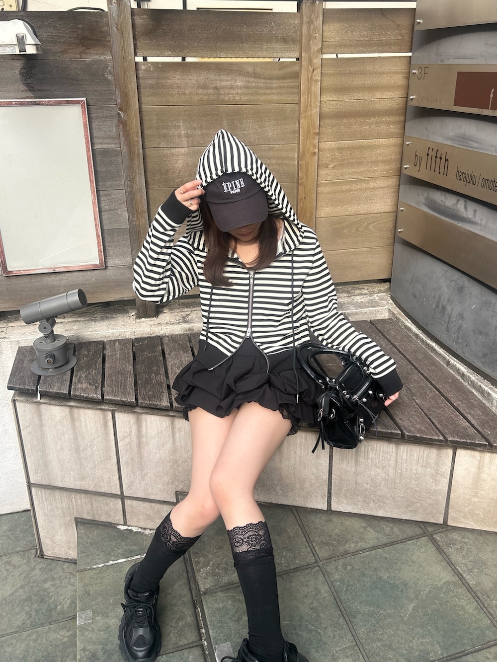 ブラック系のスカート、ブラック系のショルダーバッグ、ブラック系のソックス/靴下を着用したレディースの春コーディネートの4枚目の写真