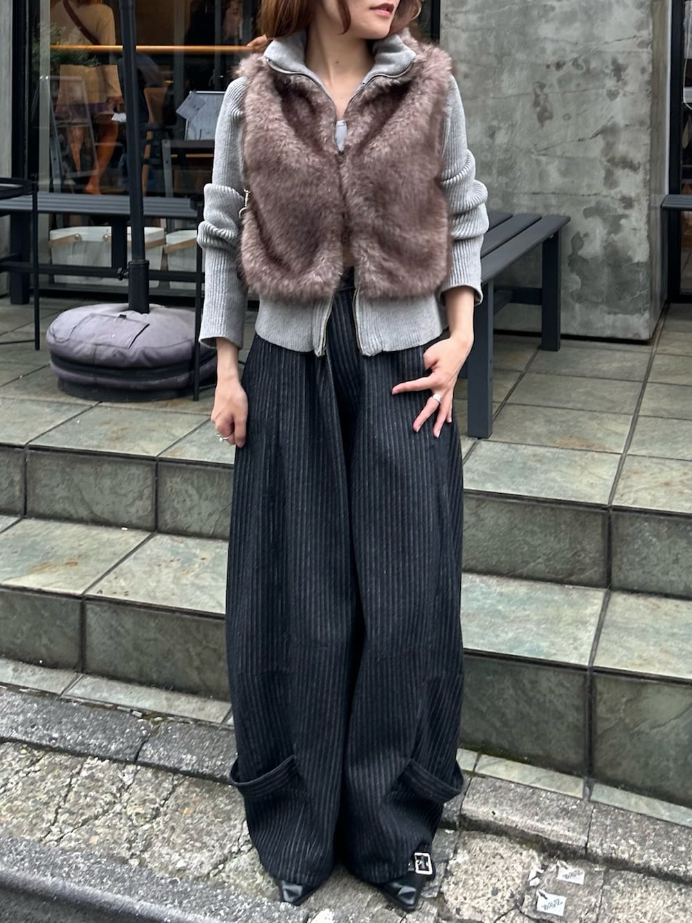 ブラウン系のニット/セーター、ブルー系のデニムパンツ、ブラック系のショルダーバッグを着用したレディースの秋コーディネートの6枚目の写真