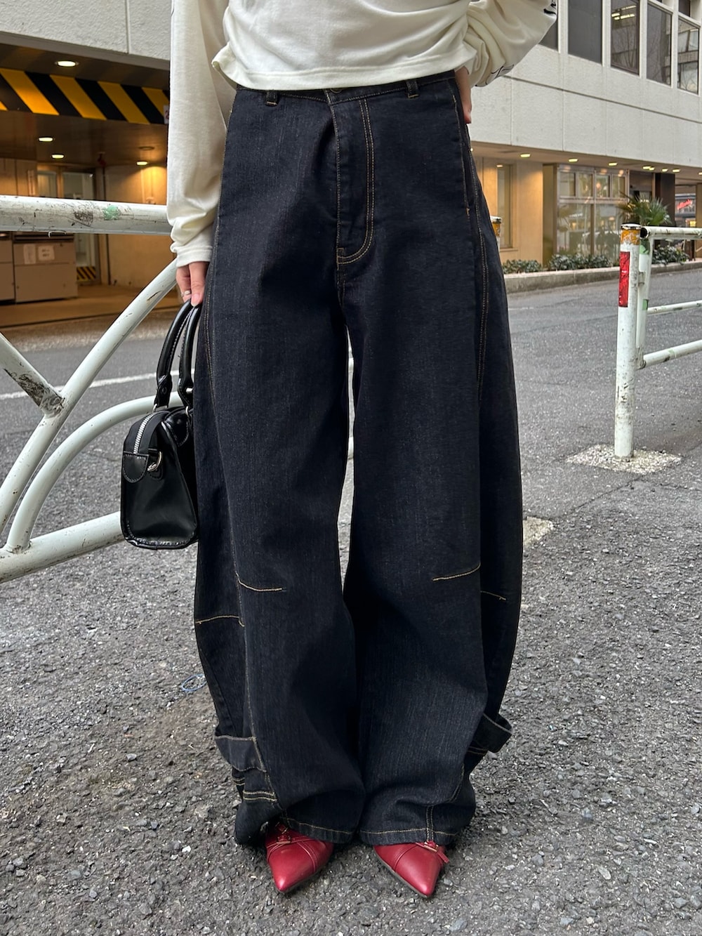 ホワイト系のTシャツ/カットソー、ブラック系のデニムパンツ、ブラック系のショルダーバッグを着用したレディースの春コーディネートの4枚目の写真