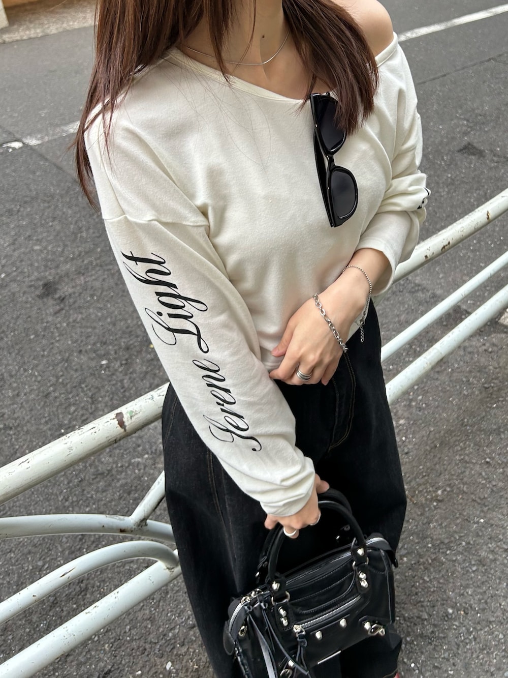 ホワイト系のTシャツ/カットソー、ブラック系のデニムパンツ、ブラック系のショルダーバッグを着用したレディースの春コーディネートの3枚目の写真