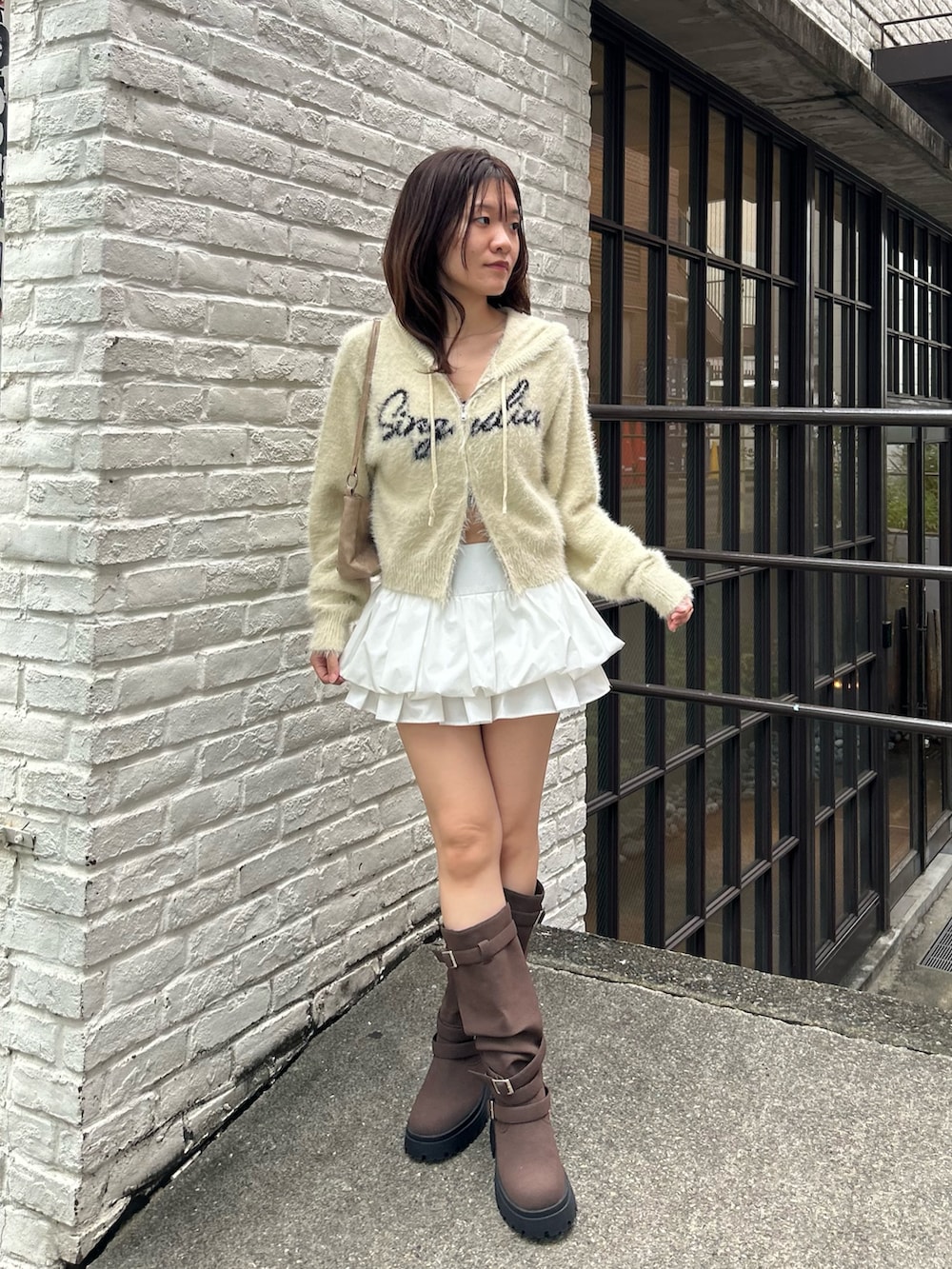 ブラウン系のブルゾン、ホワイト系のニット/セーター、ホワイト系のスカートを着用したレディースの秋コーディネートの8枚目の写真