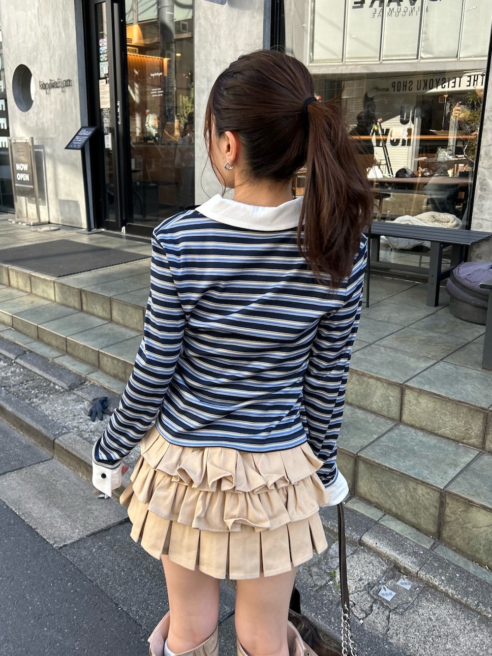 ベージュ系のブルゾン、ブルー系のTシャツ/カットソー、ベージュ系のスカートを着用したレディースの冬コーディネートの6枚目の写真