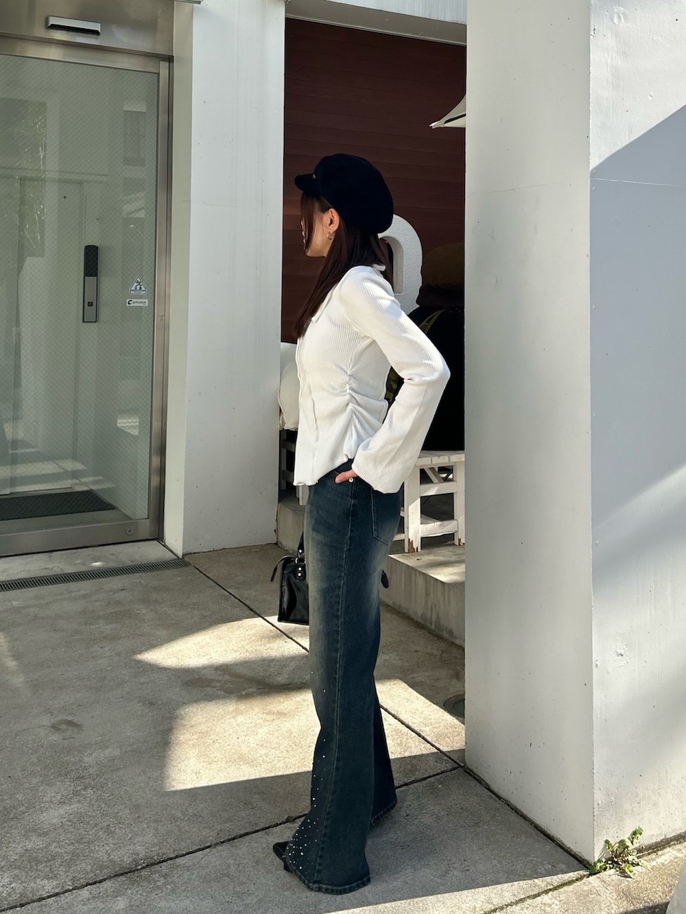 ホワイト系のTシャツ/カットソー、ブルー系のデニムパンツを着用したレディースの春コーディネートの4枚目の写真