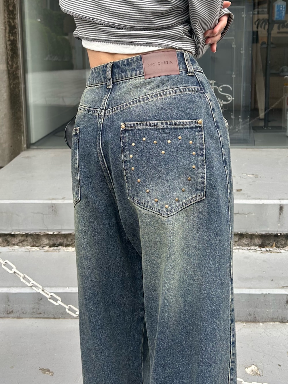 グレー系のTシャツ/カットソー、ブルー系のデニムパンツ、ブラック系のショルダーバッグを着用したレディースの春コーディネートの2枚目の写真