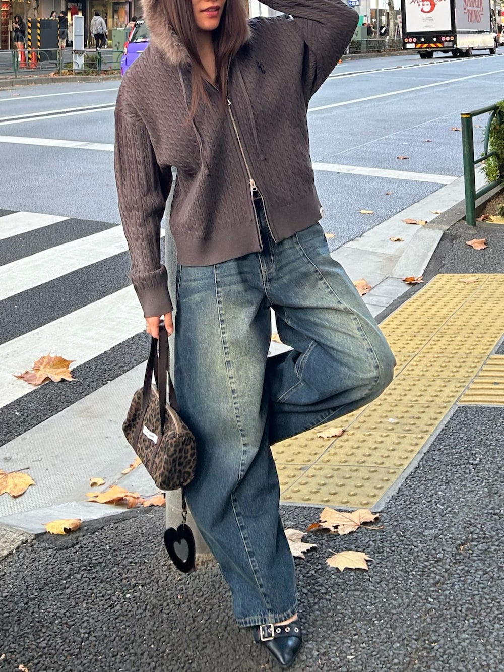 グレー系のパーカー、ブルー系のデニムパンツを着用したレディースの冬コーディネートの3枚目の写真