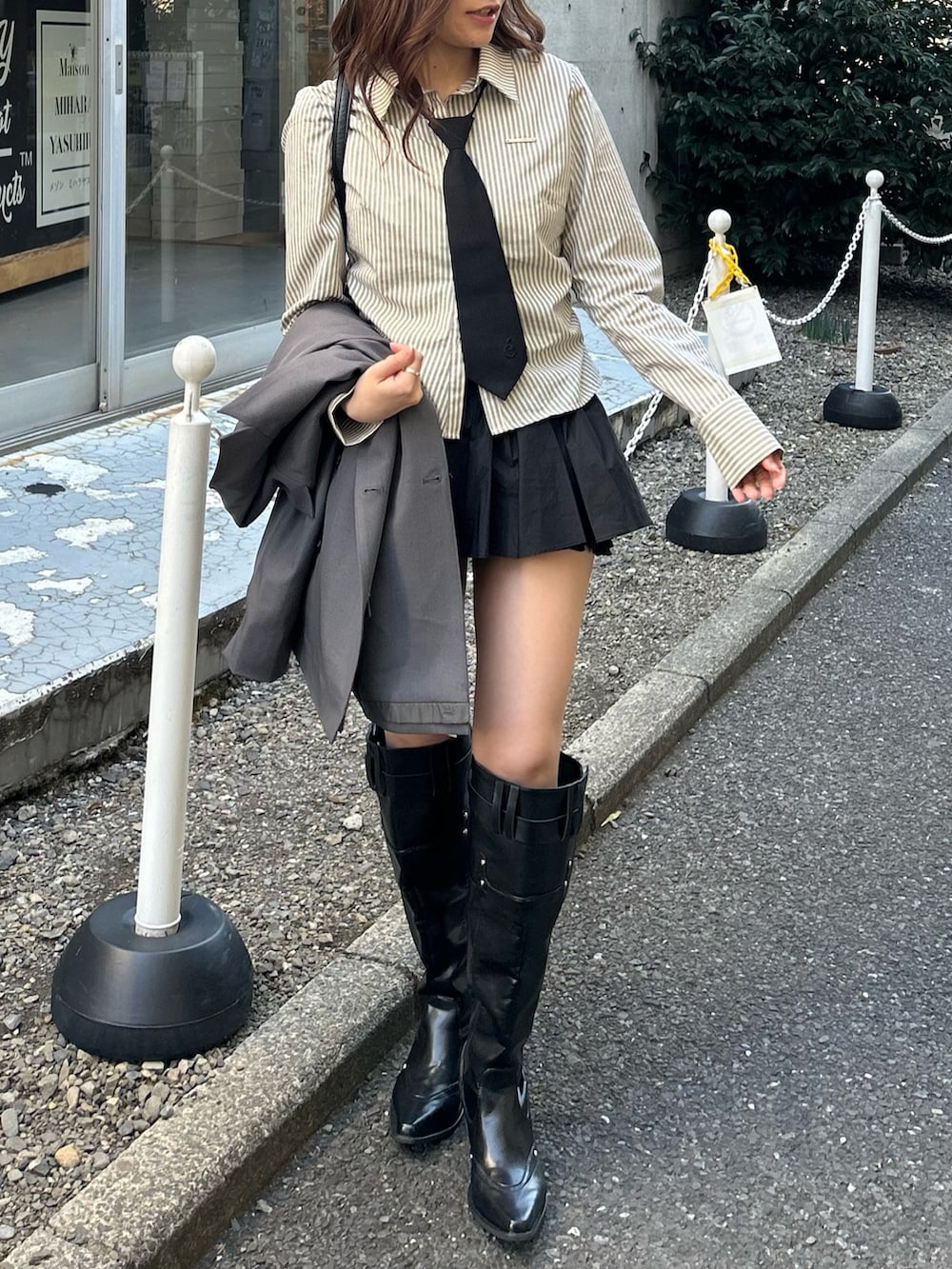 グレー系のテーラードジャケット、ブラック系のブーツを着用したレディースの冬コーディネートの2枚目の写真