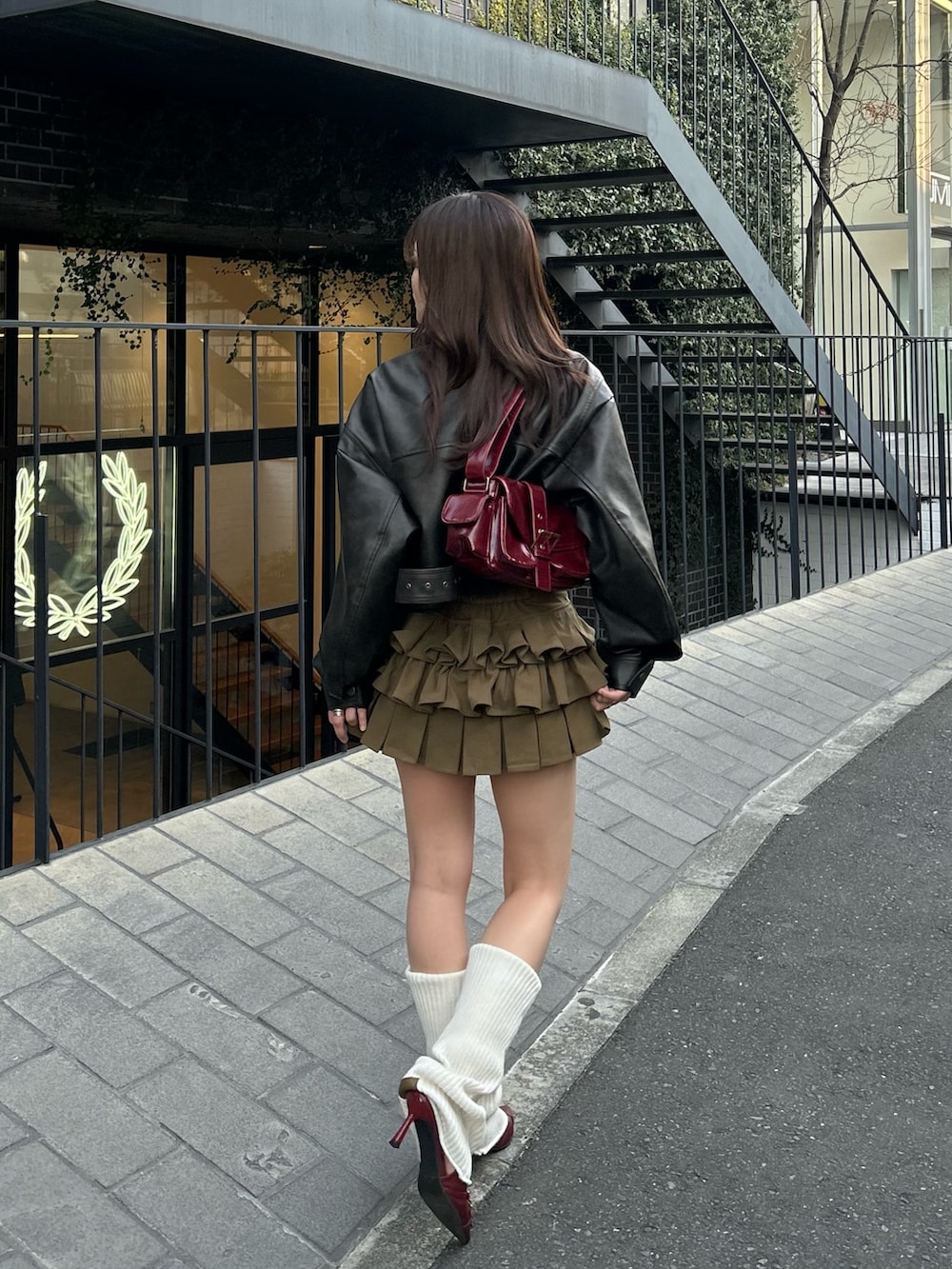 ブラウン系のその他アウター、グリーン系のスカート、ホワイト系のレッグウォーマーを着用したレディースの冬コーディネートの4枚目の写真