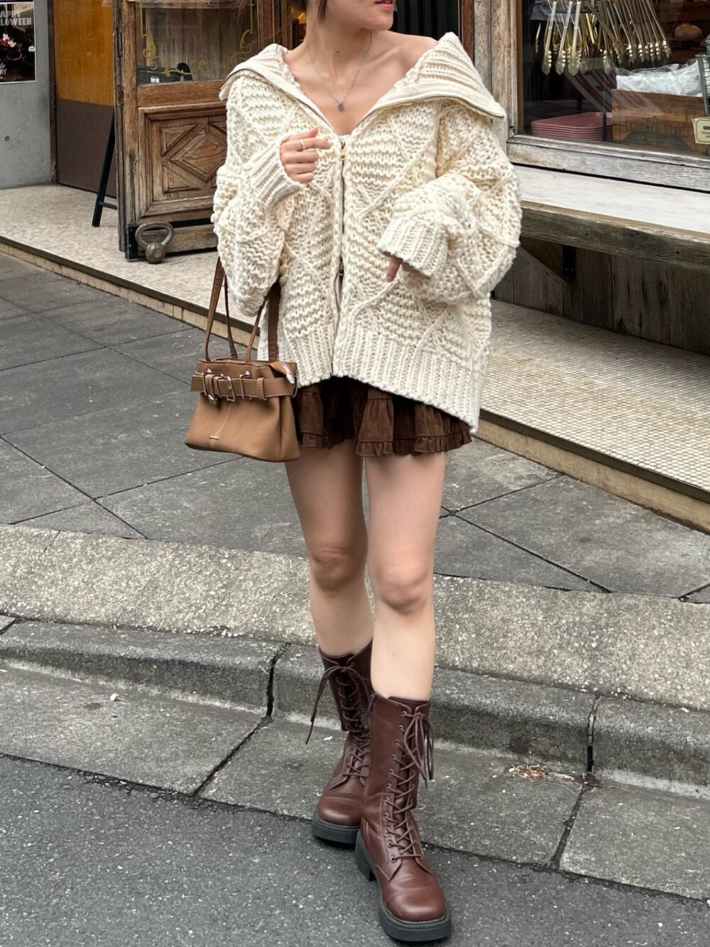 ホワイト系のニット/セーター、イエロー系のショルダーバッグ、ブラウン系のスカートを着用したレディースの秋コーディネートの3枚目の写真