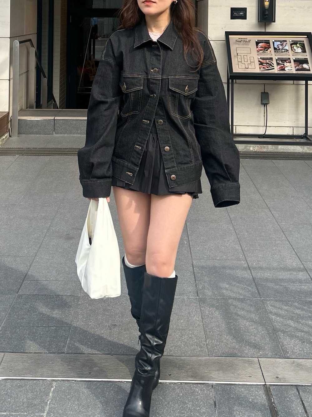 ブラック系のデニムジャケットを着用したレディースの冬コーディネートの3枚目の写真