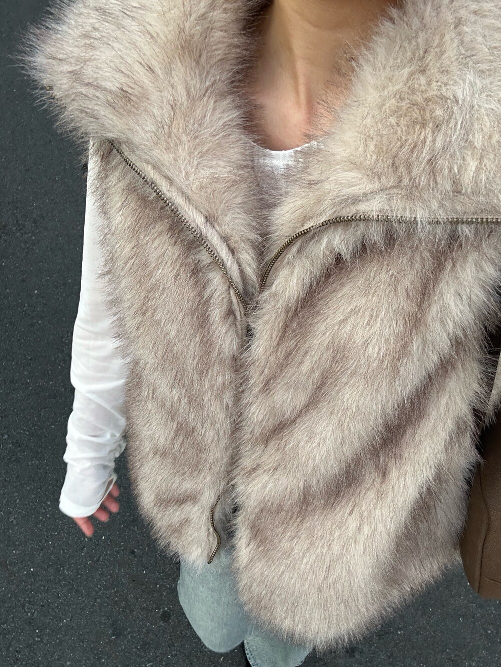 ホワイト系のシャツ/ブラウス、ホワイト系のベスト、ブルー系のデニムパンツを着用したレディースの秋コーディネートの3枚目の写真