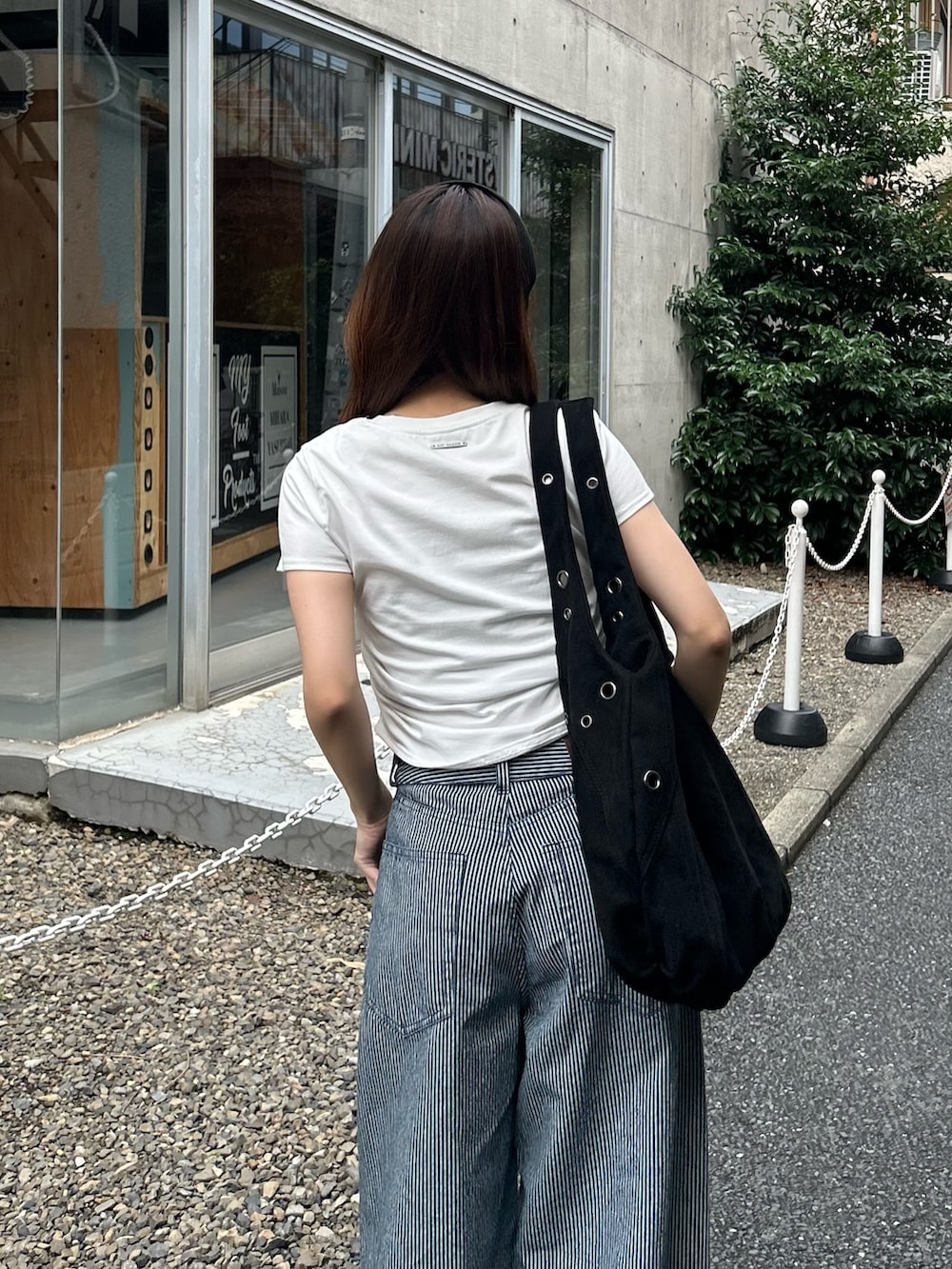 ホワイト系のTシャツ/カットソー、ブルー系のデニムパンツ、ブラック系のトートバッグを着用したレディースの夏コーディネートの4枚目の写真