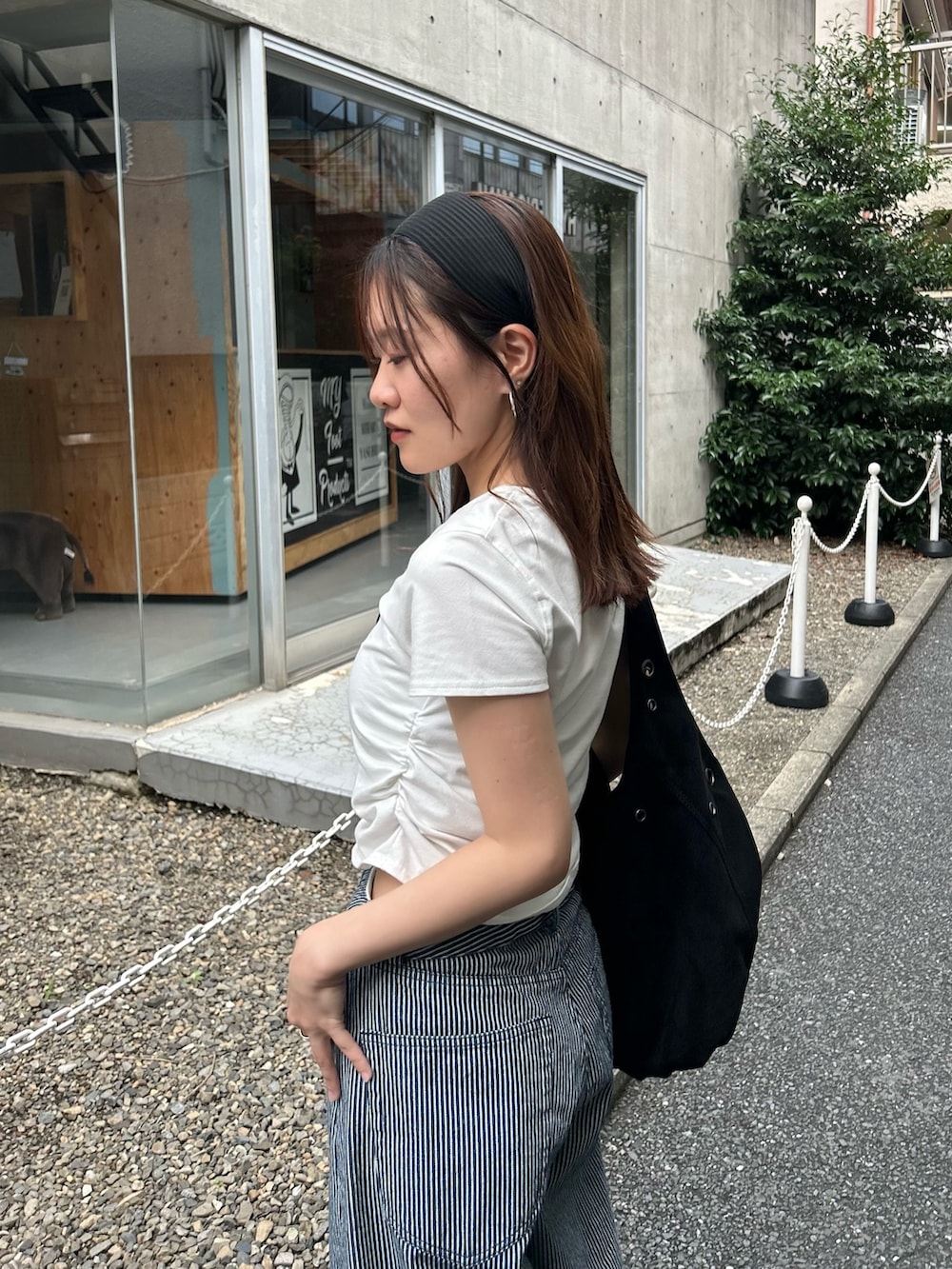 ホワイト系のTシャツ/カットソー、ブルー系のデニムパンツ、ブラック系のトートバッグを着用したレディースの夏コーディネートの3枚目の写真