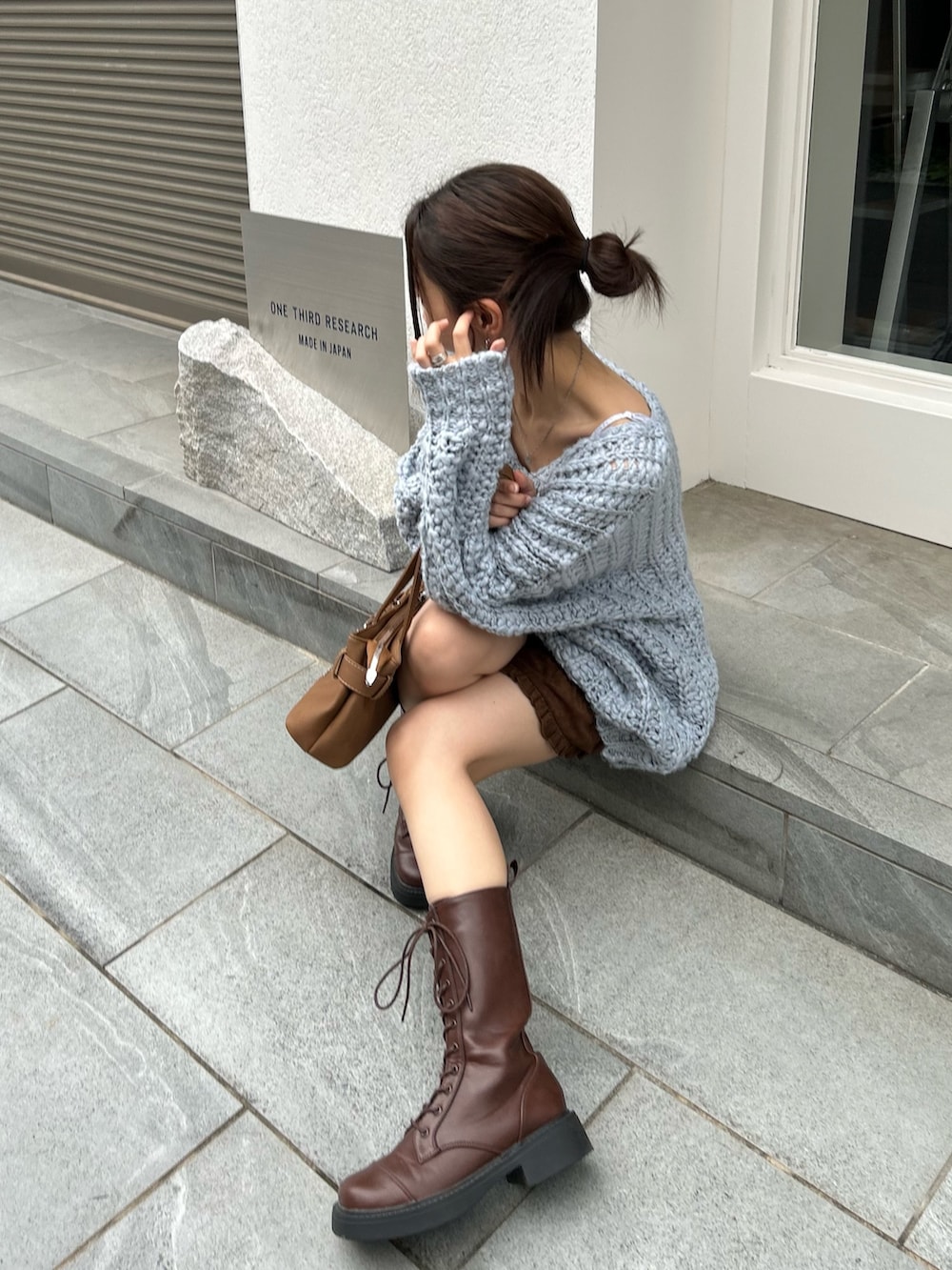 ブルー系のニット/セーター、ブラウン系のスカートを着用したレディースの秋コーディネートの6枚目の写真