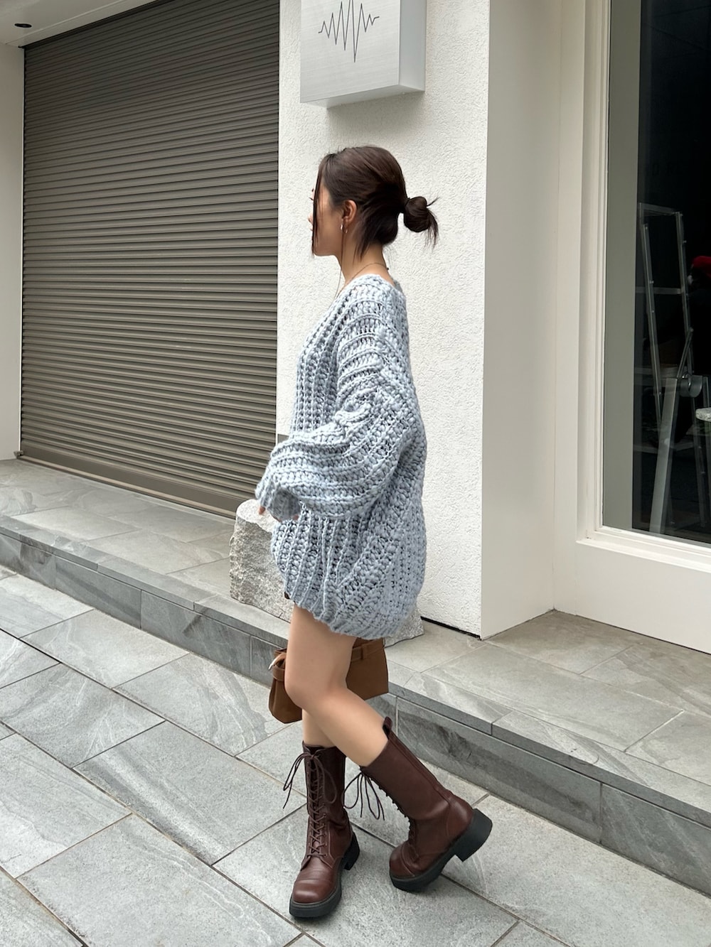 ブルー系のニット/セーター、ブラウン系のスカートを着用したレディースの秋コーディネートの3枚目の写真