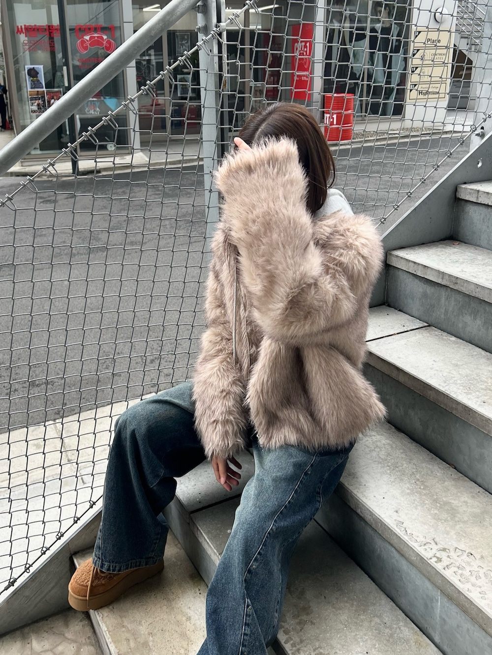 ブルー系のデニムパンツ、ブラック系のトートバッグ、イエロー系のブーツを着用したレディースの秋コーディネートの6枚目の写真