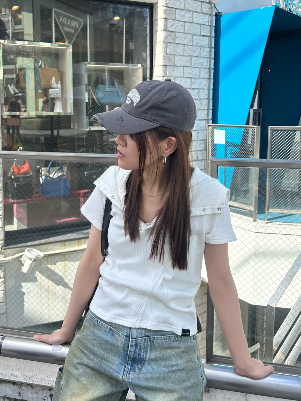 ホワイト系のTシャツ/カットソー、ブルー系のデニムパンツ、グレー系のキャップを着用したレディースの春コーディネートの5枚目の写真
