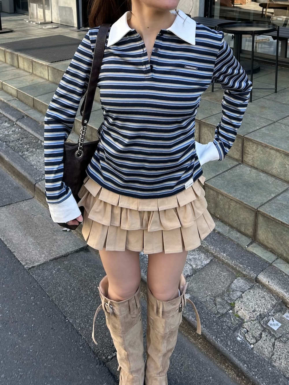 ベージュ系のブルゾン、ブルー系のTシャツ/カットソー、ベージュ系のスカートを着用したレディースの冬コーディネートの4枚目の写真