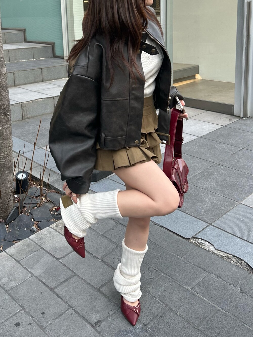 ブラウン系のその他アウター、グリーン系のスカート、ホワイト系のレッグウォーマーを着用したレディースの冬コーディネートの6枚目の写真