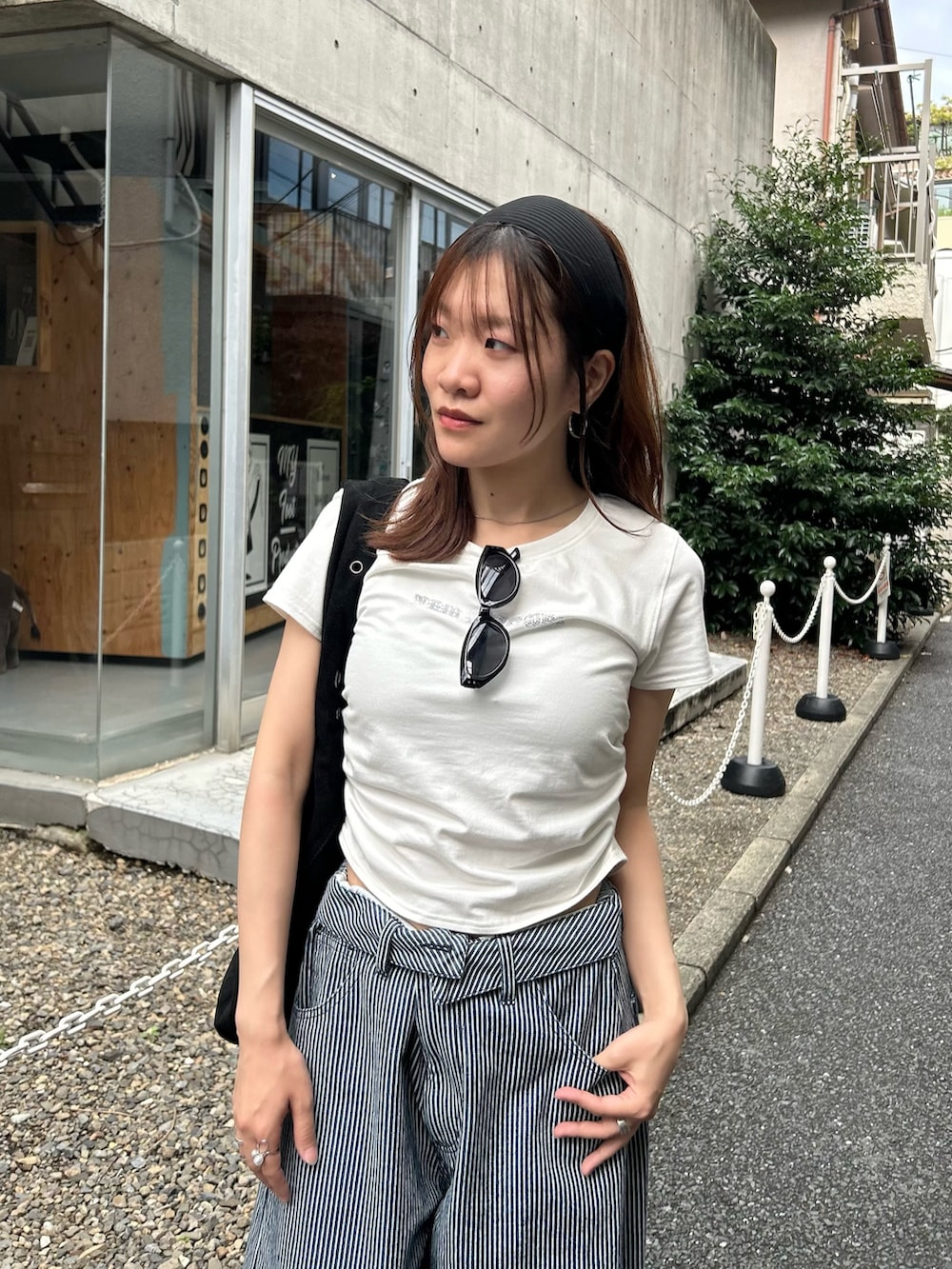 ホワイト系のTシャツ/カットソー、ブルー系のデニムパンツ、ブラック系のトートバッグを着用したレディースの夏コーディネートの2枚目の写真