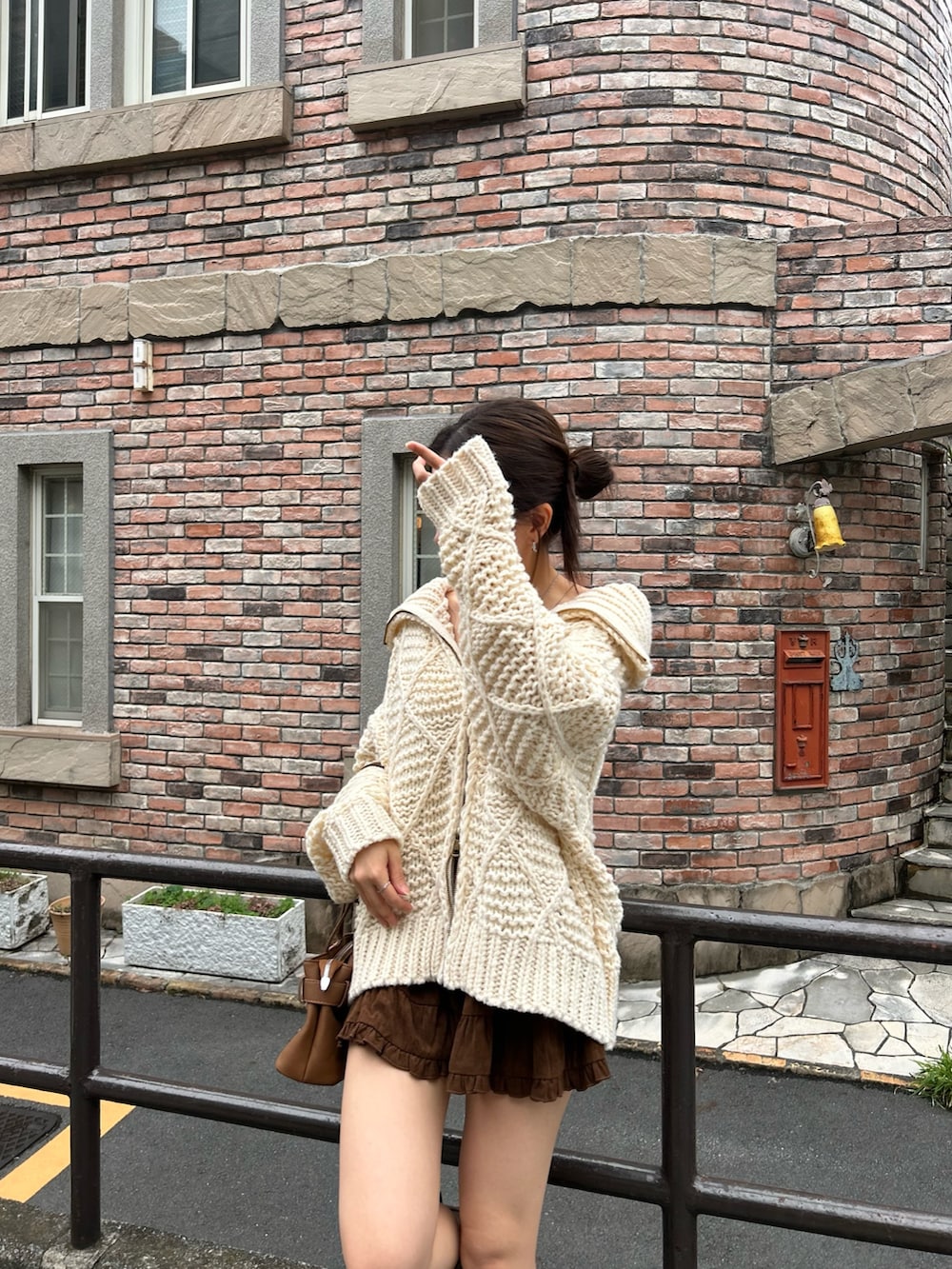 ホワイト系のニット/セーター、イエロー系のショルダーバッグ、ブラウン系のスカートを着用したレディースの秋コーディネートの5枚目の写真