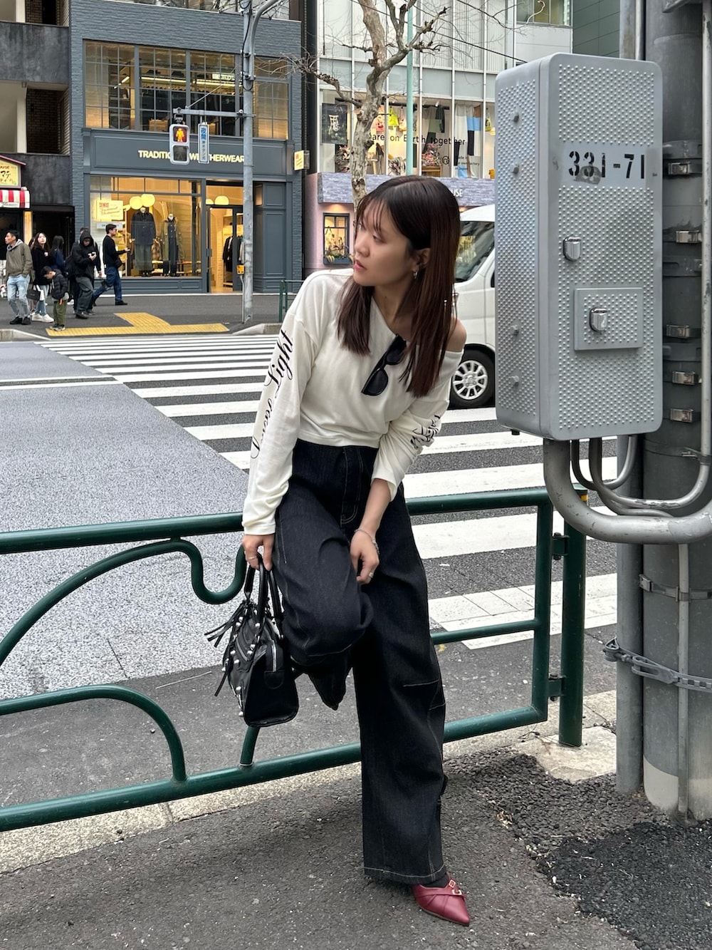 ホワイト系のTシャツ/カットソー、ブラック系のデニムパンツ、ブラック系のショルダーバッグを着用したレディースの春コーディネートの2枚目の写真