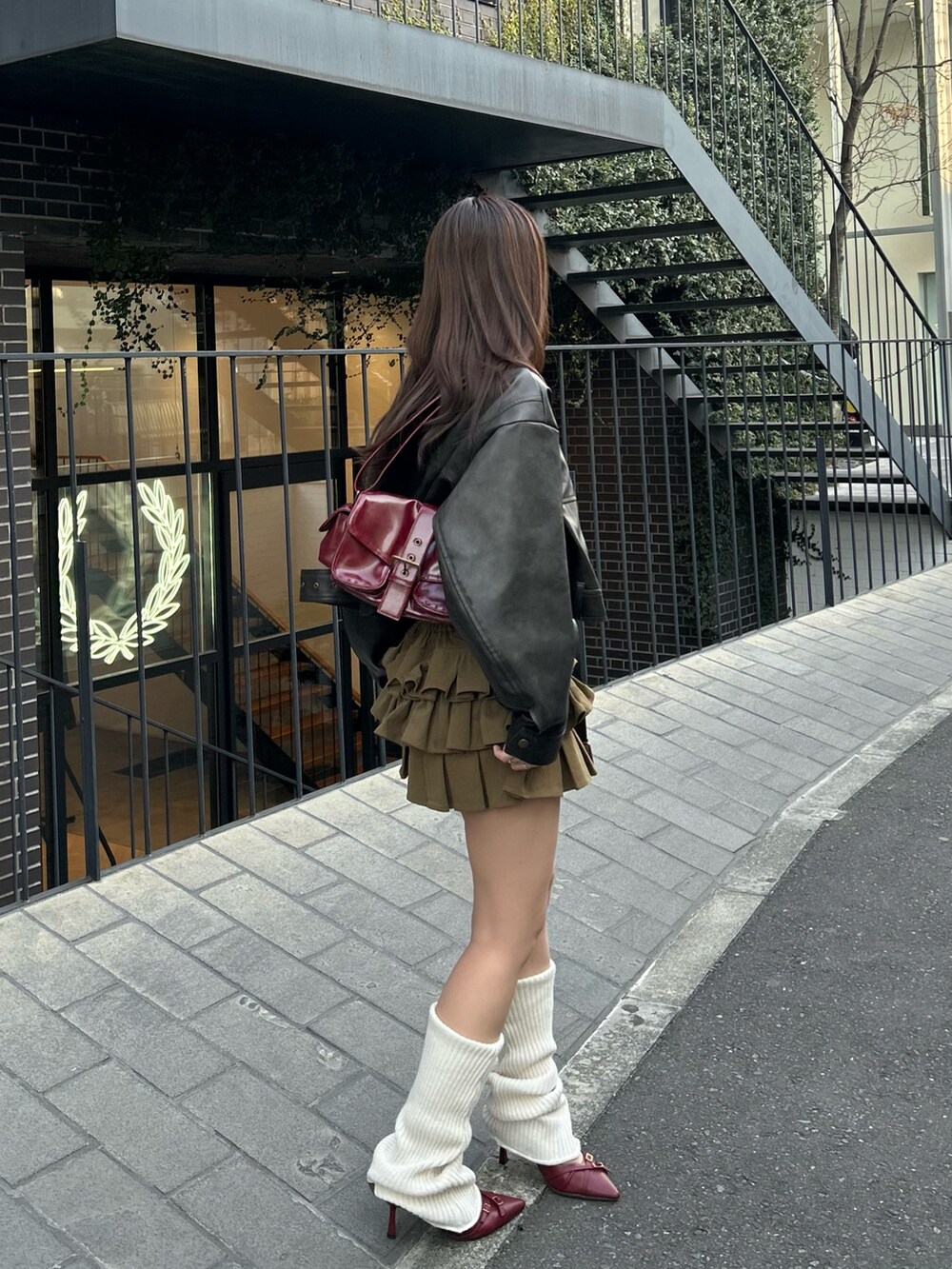 ブラウン系のその他アウター、グリーン系のスカート、ホワイト系のレッグウォーマーを着用したレディースの冬コーディネートの3枚目の写真