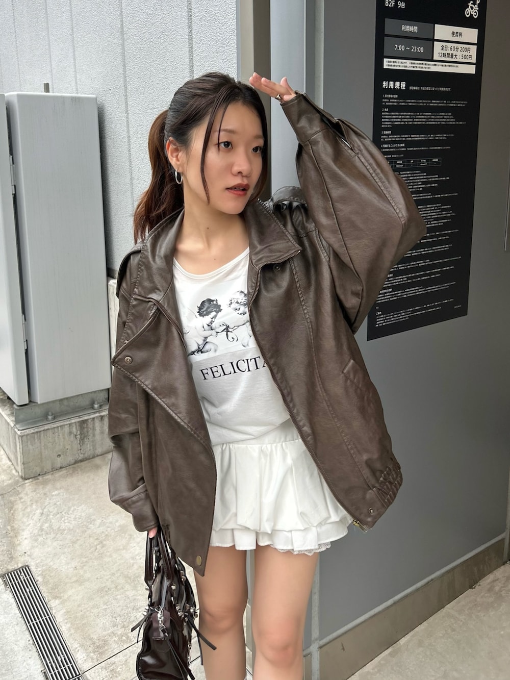 ブラウン系のブルゾン、ホワイト系のTシャツ/カットソー、ホワイト系のスカートを着用したレディースの秋コーディネートの4枚目の写真