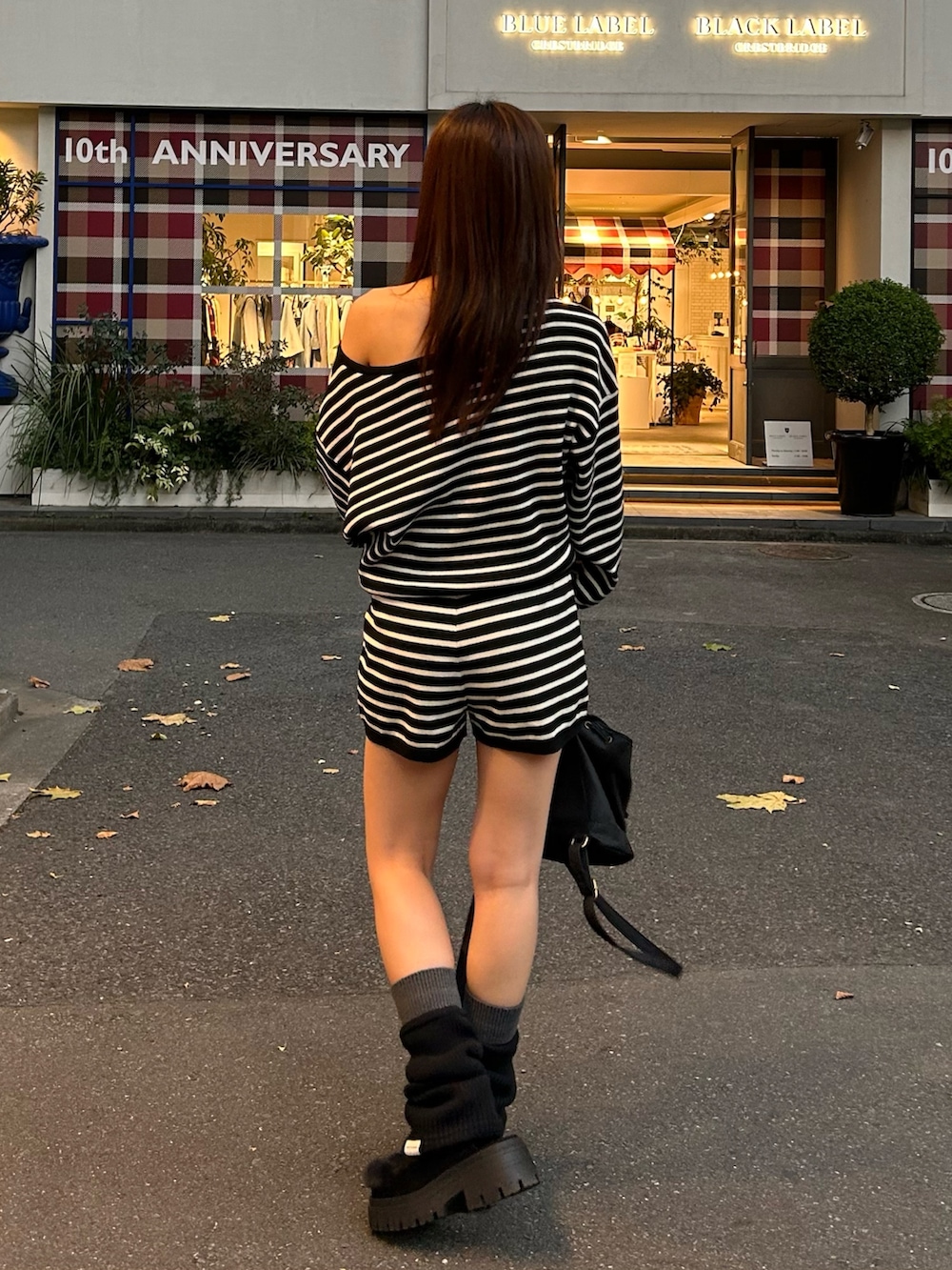 ブラック系のニット/セーター、ブラック系のその他パンツ、ブラック系のバックパック/リュックを着用したレディースの秋コーディネートの4枚目の写真