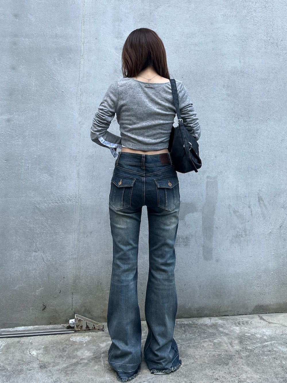 グレー系のカーディガン/ボレロ、ブルー系のデニムパンツ、ブラック系のショルダーバッグを着用したレディースの夏コーディネートの2枚目の写真