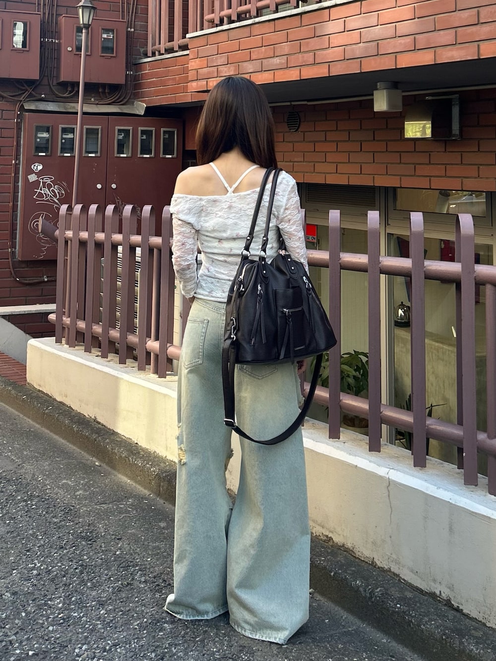ホワイト系のTシャツ/カットソー、ブルー系のデニムパンツ、ブラウン系のショルダーバッグを着用したレディースの夏コーディネートの3枚目の写真