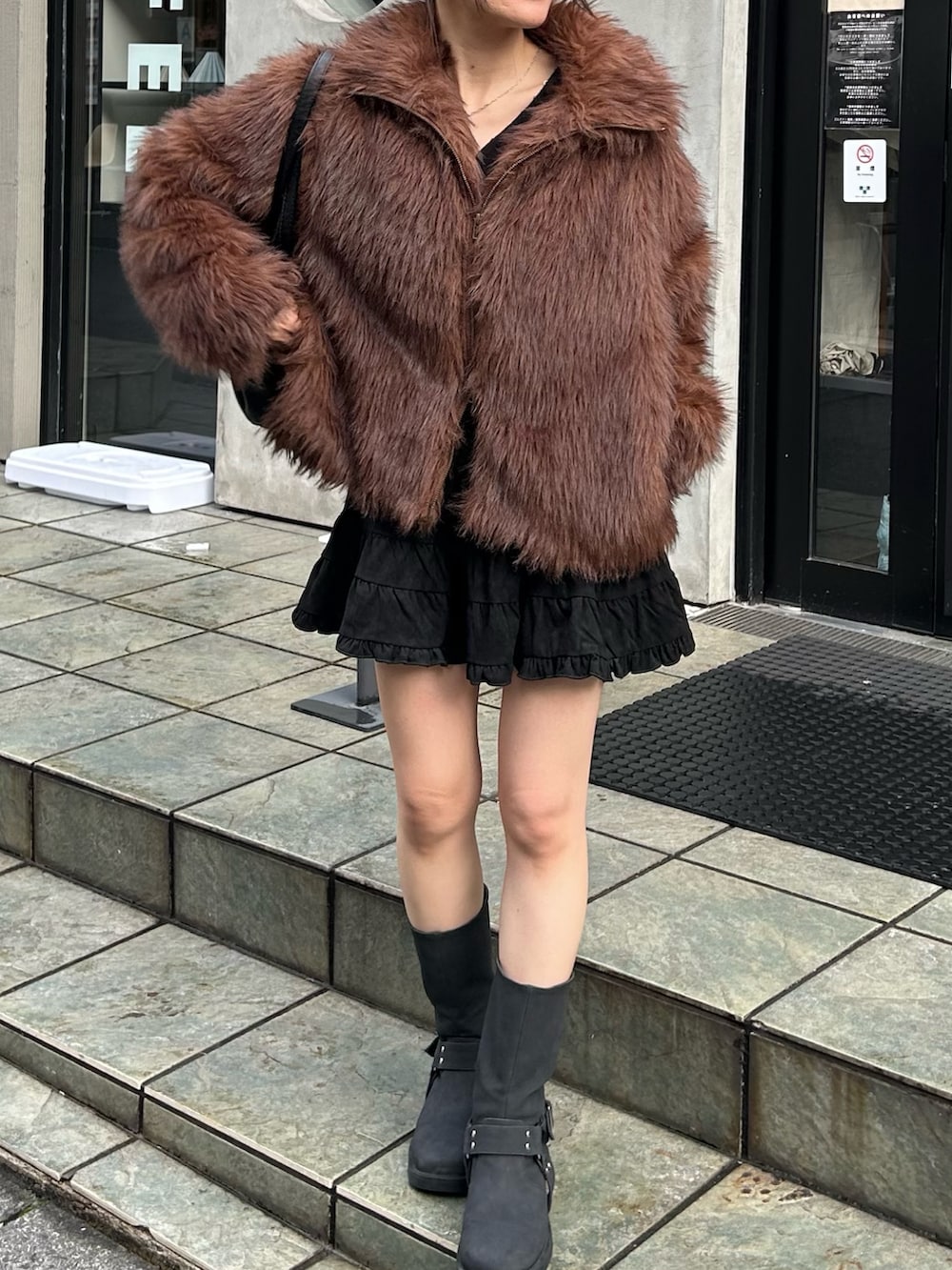 ブラック系のショルダーバッグ、ブラック系のブーツ、ブラック系のスカートを着用したレディースの秋コーディネートの4枚目の写真