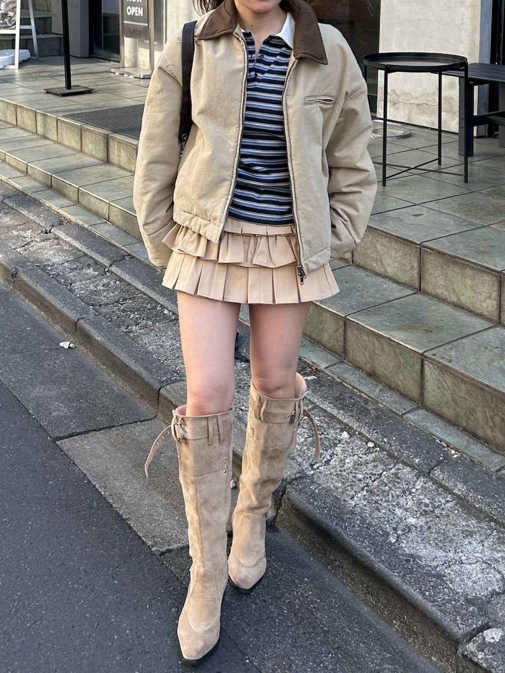 ベージュ系のブルゾン、ブルー系のTシャツ/カットソー、ベージュ系のスカートを着用したレディースの冬コーディネートの8枚目の写真