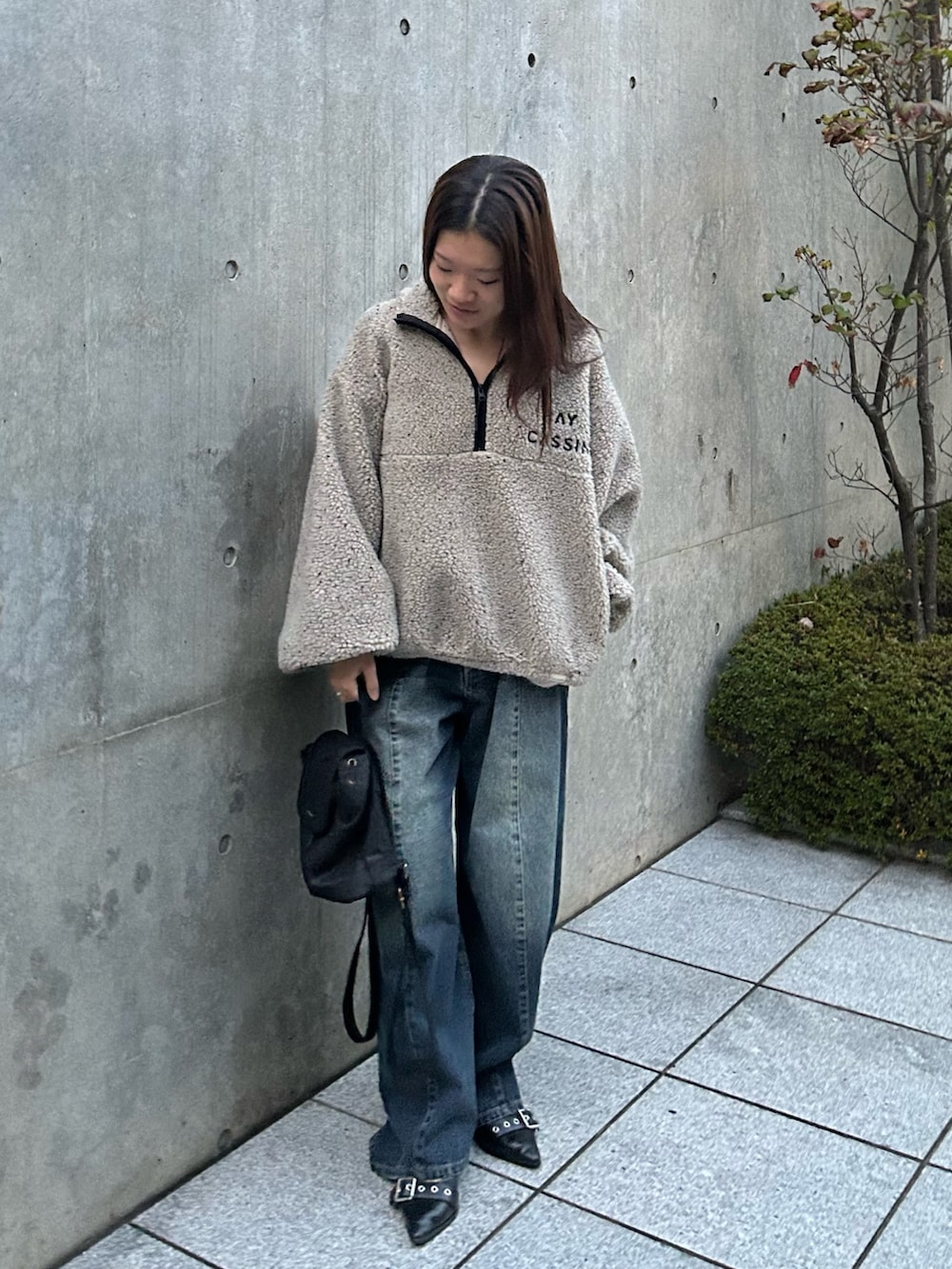 ベージュ系のスウェット、ブルー系のデニムパンツを着用したレディースの冬コーディネートの2枚目の写真