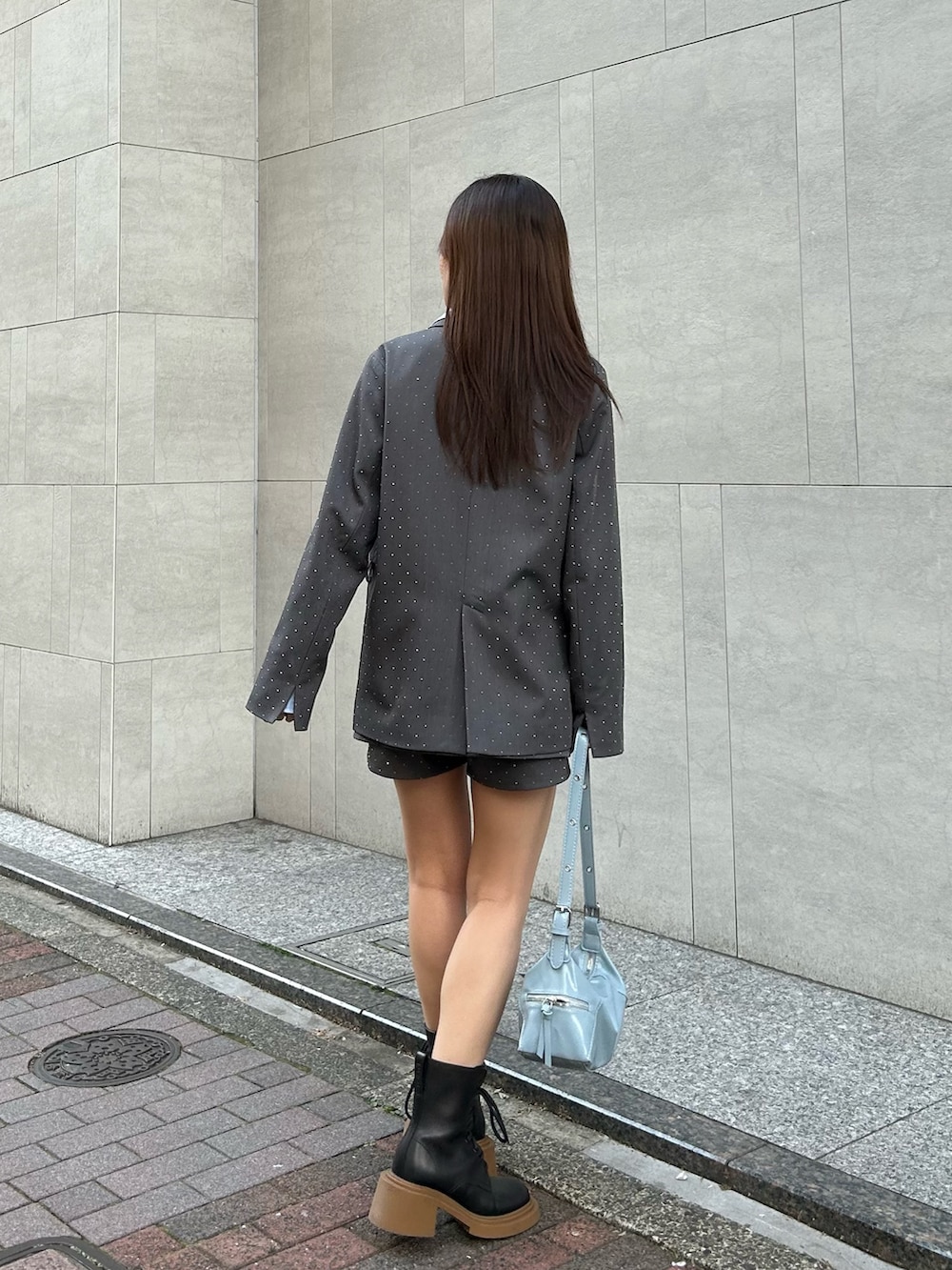 グレー系のテーラードジャケット、グレー系のスカートを着用したレディースの春コーディネートの3枚目の写真