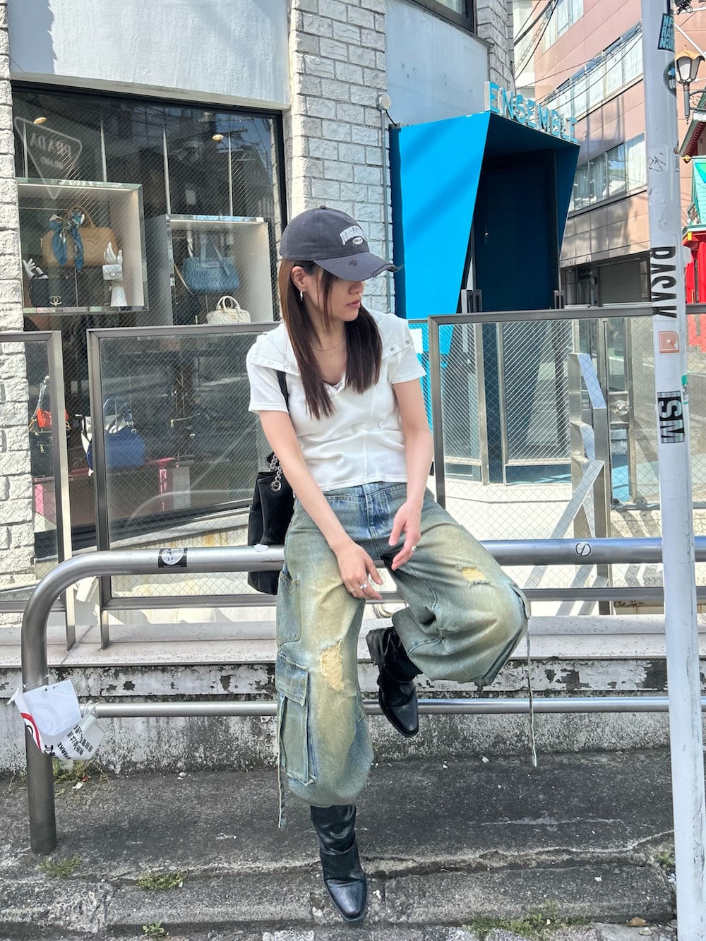 ホワイト系のTシャツ/カットソー、ブルー系のデニムパンツ、グレー系のキャップを着用したレディースの春コーディネートの6枚目の写真