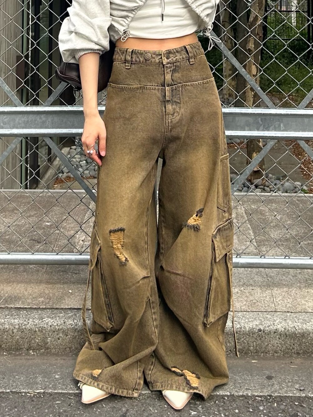 ホワイト系のカーディガン/ボレロ、ベージュ系のデニムパンツ、ホワイト系のキャップを着用したレディースの春コーディネートの4枚目の写真