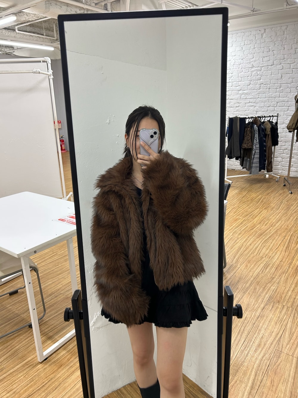 ブラック系のショルダーバッグ、ブラック系のブーツ、ブラック系のスカートを着用したレディースの秋コーディネートの7枚目の写真