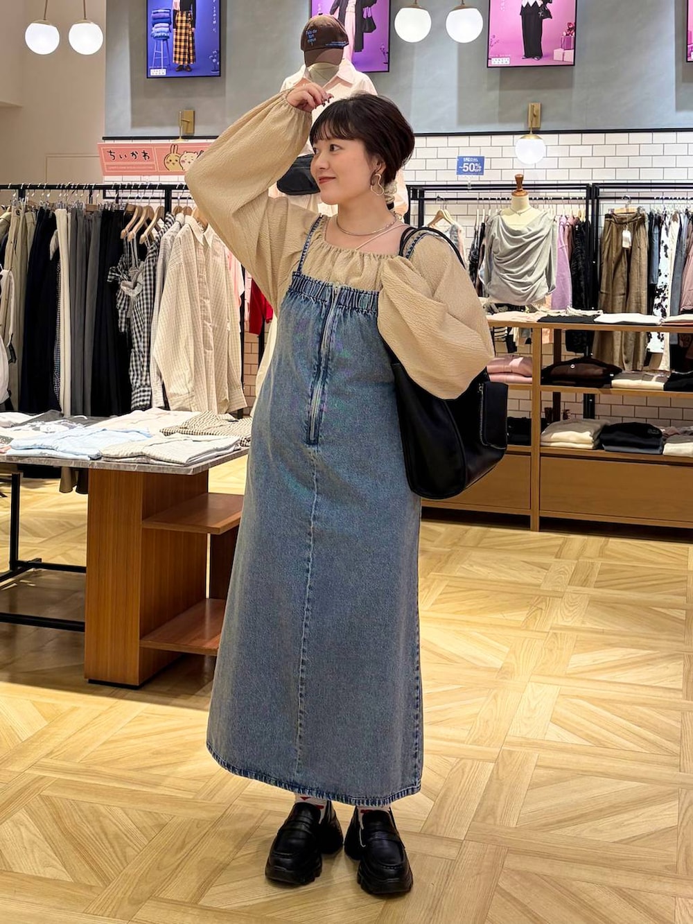 ブラック系のローファー、ブルー系のワンピース、ブラック系のトートバッグを着用したレディースの冬コーディネートの2枚目の写真