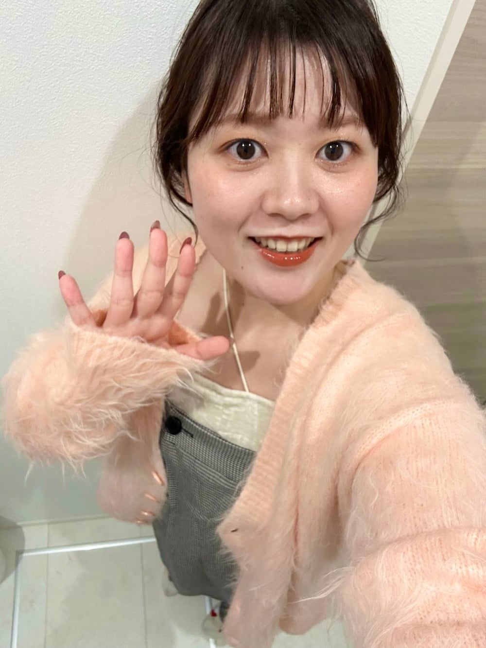 ブラック系のサンダル、ブラウン系のボストンバッグ、ピンク系のカーディガン/ボレロを着用したレディースの秋コーディネートの3枚目の写真