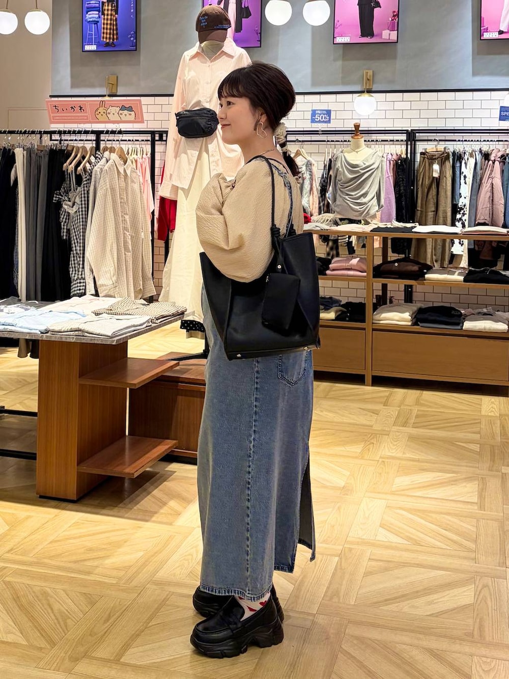 ブラック系のローファー、ブルー系のワンピース、ブラック系のトートバッグを着用したレディースの冬コーディネートの3枚目の写真