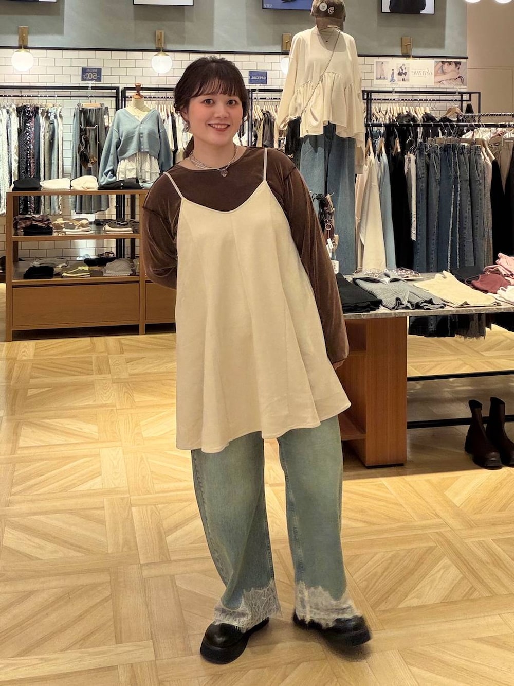 ホワイト系のスカート、ブラウン系のTシャツ/カットソー、ブルー系のデニムパンツを着用したレディースの秋コーディネートの4枚目の写真